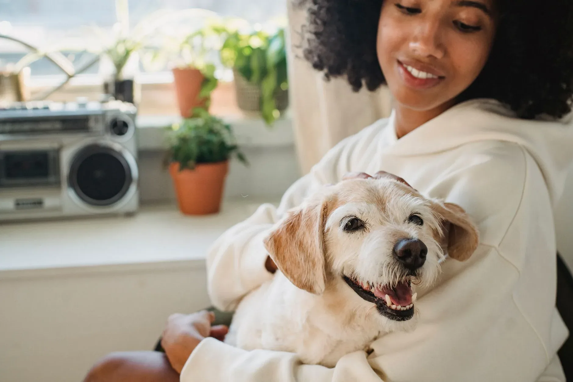 A woman at home hugging her dog